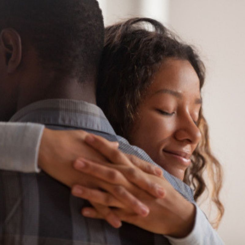 Two individuals embracing one another